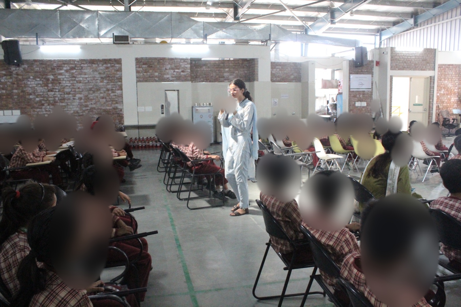 Tamana leading a student workshop, children's faces blurred for privacy
